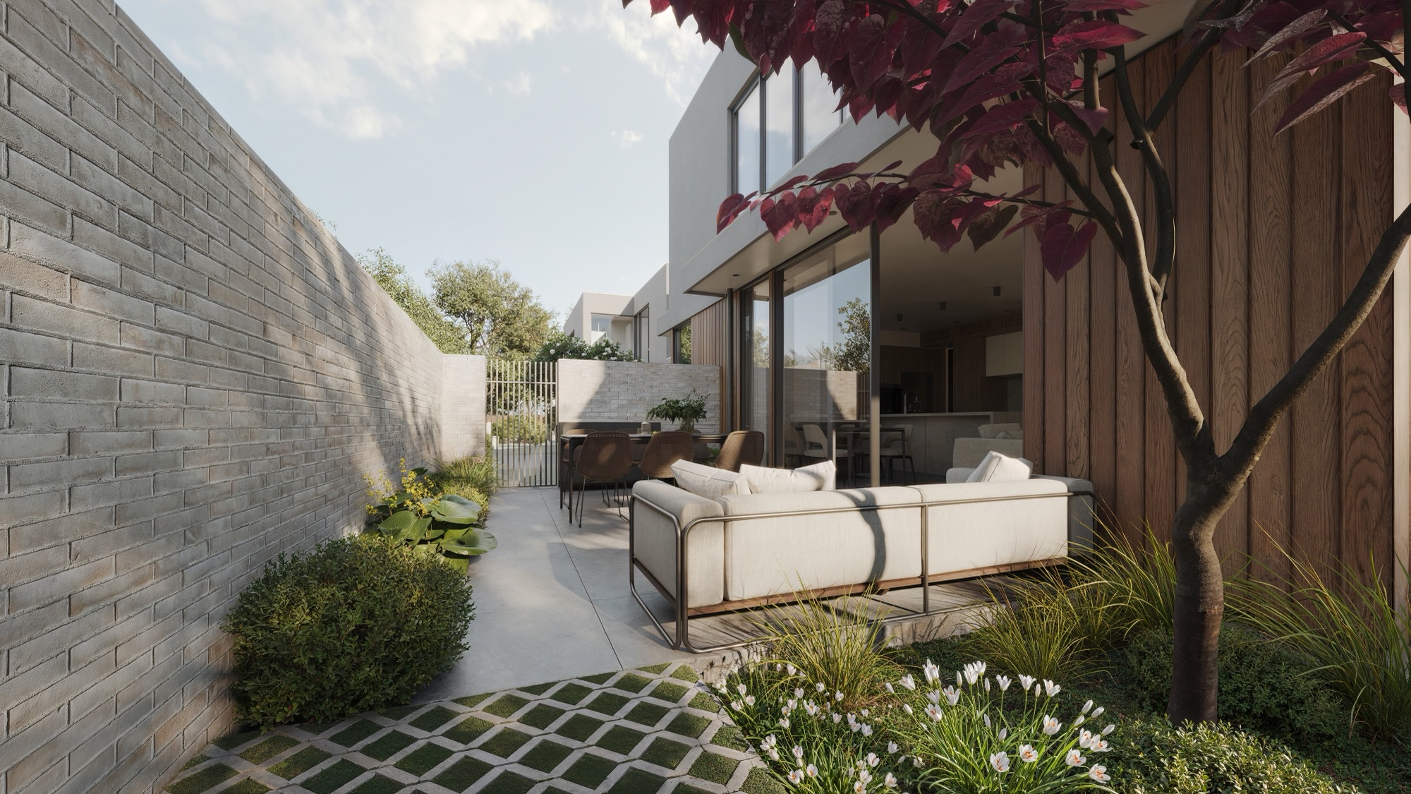 Photorealistic render of the Browns Road courtyard with grass-jointed pavers, outdoor sofa and grey brick wall by Render Works