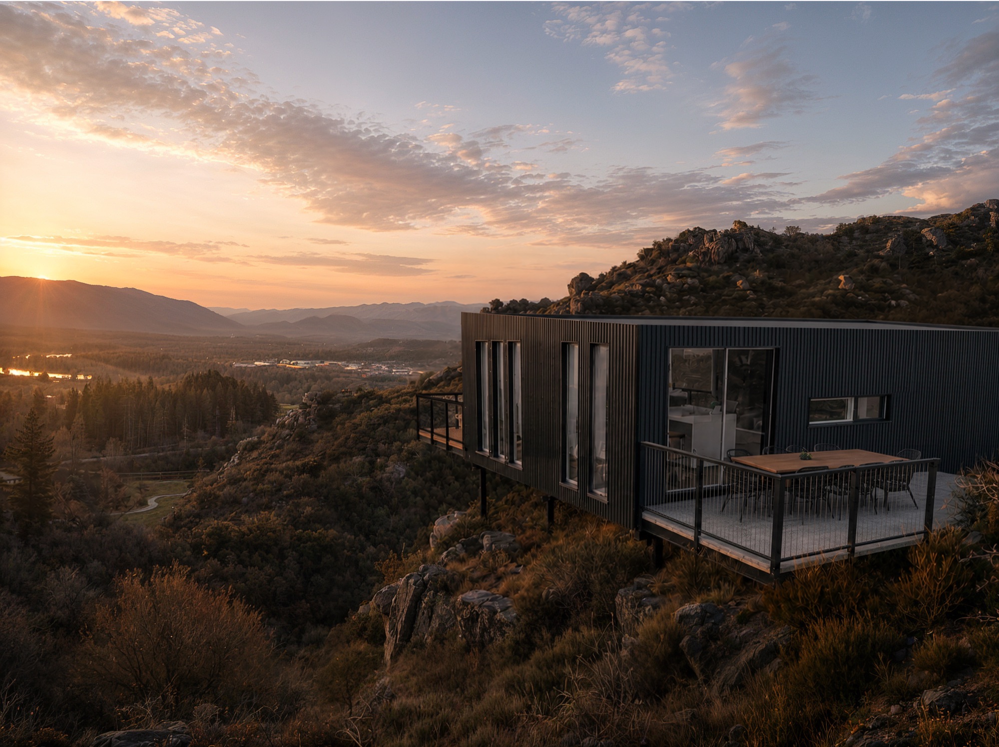 Photorealistic sunset render of the charcoal-clad Lanes Road home and deck over a rocky slope in Central Otago by Render Works